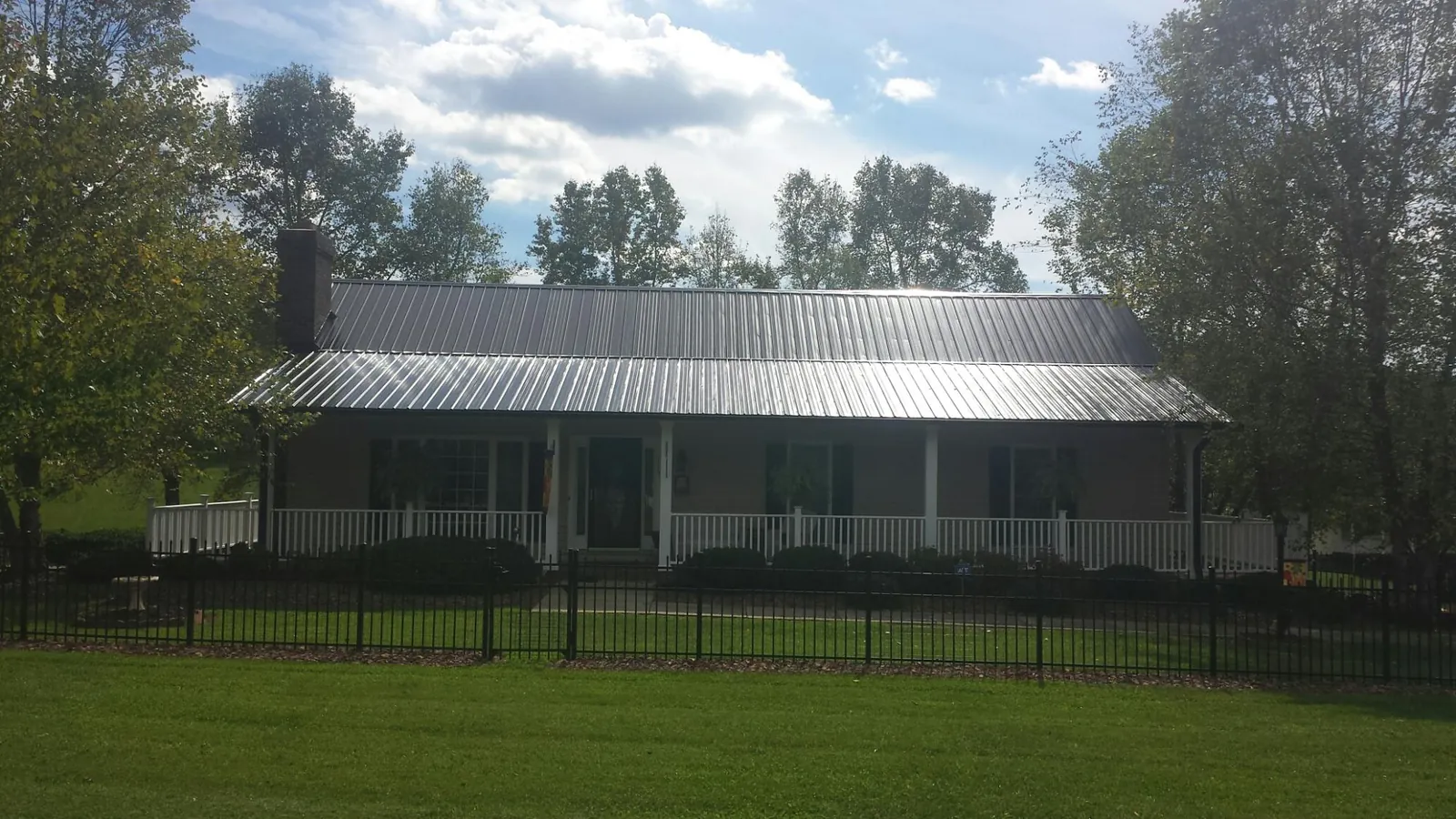 Gray metal roof on a brick ranch with a full width front porch — Gutter Guard Installation work by our crew in Lebanon